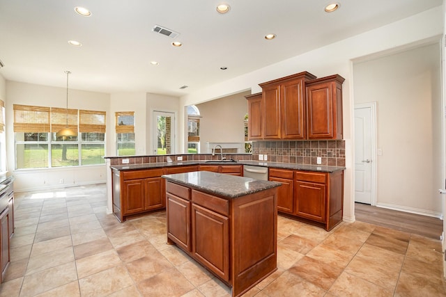 549 Verbena Ln, Frisco, TX 75036 - kitchen with a sink, a peninsula, recessed lighting, brown cabinets, and backsplash