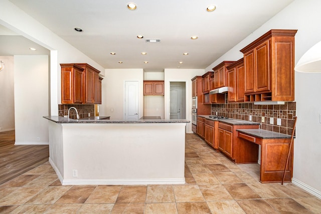 549 Verbena Ln, Frisco, TX 75036 - kitchen with a peninsula, backsplash, recessed lighting, baseboards, and brown cabinets