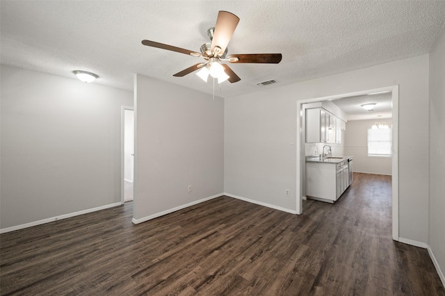 230 NE Craig St, Burleson, TX 76028 - empty room with dark wood-type flooring, a sink, ceiling fan, a textured ceiling, and baseboards
