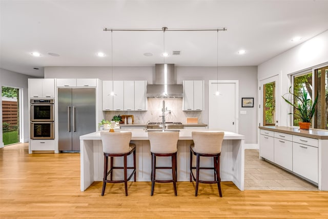 5624 Melshire Dr, Dallas, TX 75230 - kitchen with stainless steel appliances, wall chimney range hood, recessed lighting, plenty of natural light, and decorative backsplash