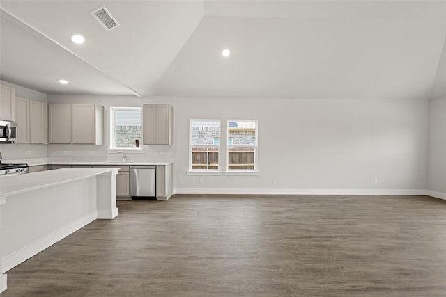 6728 Rockshire, Fort Worth, TX 76123 - kitchen featuring appliances with stainless steel finishes, vaulted ceiling, light countertops, open floor plan, and dark wood-type flooring