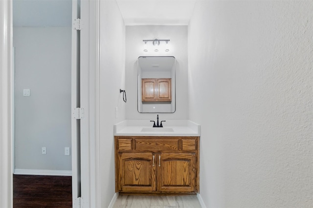 1625 Walnut St, Grand Prairie, TX 75050 - bathroom featuring wood finished floors, vanity, and baseboards