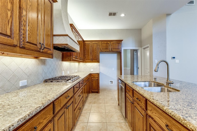 225 Tipperary Dr, Keller, TX 76248 - kitchen with stainless steel appliances, custom range hood, brown cabinetry, a sink, and light stone counters