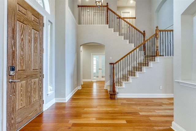 225 Tipperary Dr, Keller, TX 76248 - foyer with arched walkways, stairs, wood finished floors, a high ceiling, and baseboards