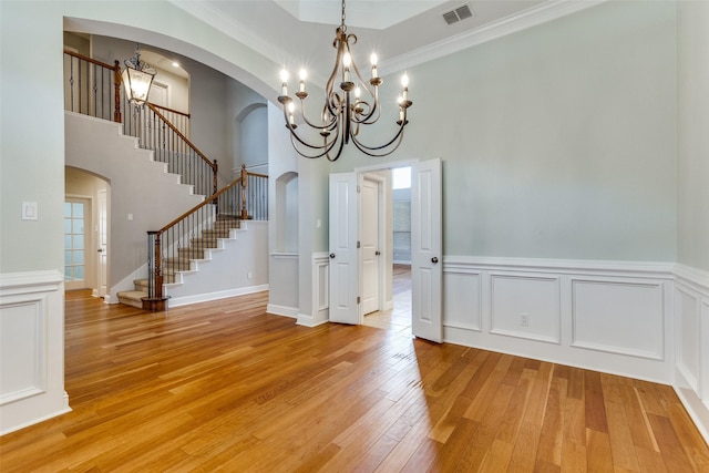 225 Tipperary Dr, Keller, TX 76248 - unfurnished dining area featuring a chandelier, arched walkways, stairway, light wood finished floors, and crown molding