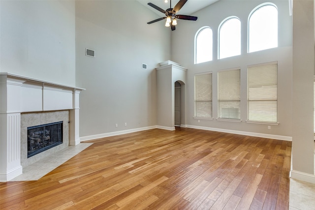 225 Tipperary Dr, Keller, TX 76248 - unfurnished living room featuring a high ceiling, a fireplace, ceiling fan, light wood-style floors, and baseboards