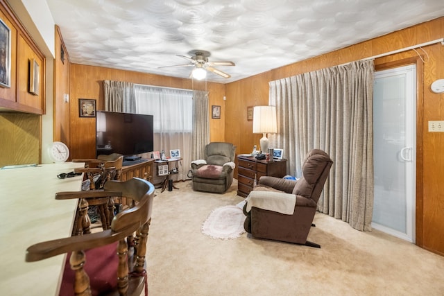1728 Foster Dr, Arlington, TX 76012 - living area with carpet, wood walls, and a ceiling fan