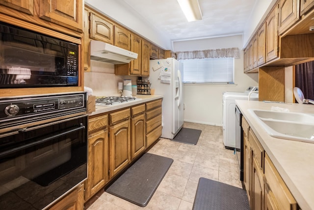 1728 Foster Dr, Arlington, TX 76012 - kitchen with black appliances, washing machine and dryer, under cabinet range hood, and light countertops