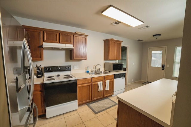 4009 Shiraz Dr, Denton, TX 76226 - kitchen featuring appliances with stainless steel finishes, a sink, under cabinet range hood, light countertops, and light tile patterned floors