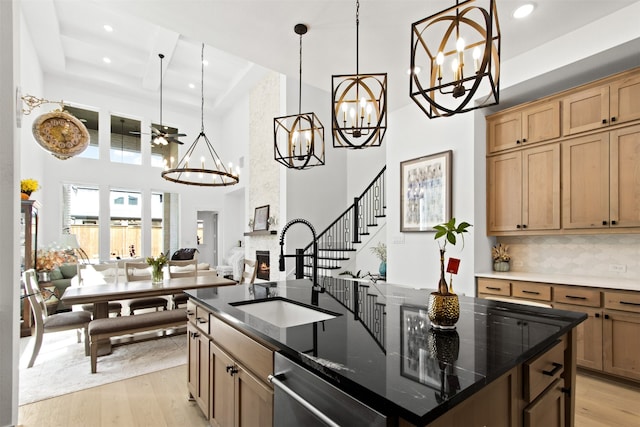 16098 Garganey Ct, Frisco, TX 75035 - kitchen featuring a sink, a chandelier, a towering ceiling, stainless steel dishwasher, and light wood-type flooring