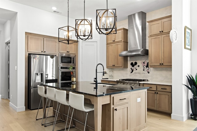 16098 Garganey Ct, Frisco, TX 75035 - kitchen with appliances with stainless steel finishes, a chandelier, a sink, wall chimney range hood, and light wood-style flooring