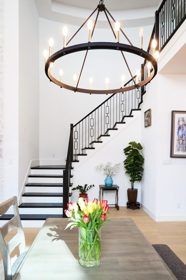 16098 Garganey Ct, Frisco, TX 75035 - staircase featuring a chandelier, wood finished floors, baseboards, and a towering ceiling