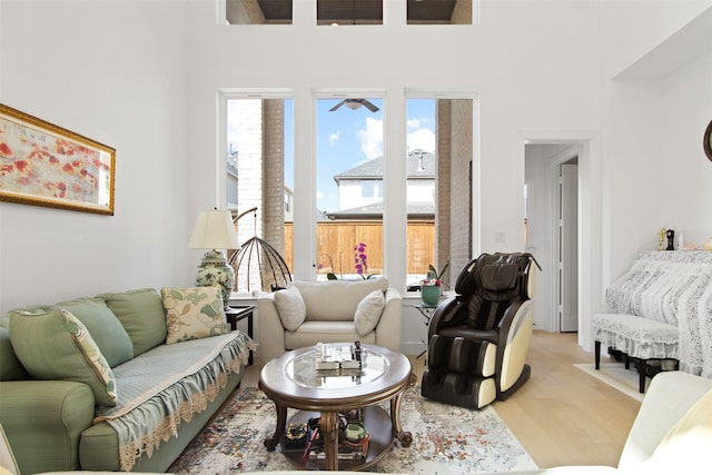 16098 Garganey Ct, Frisco, TX 75035 - living room featuring healthy amount of natural light, light wood-style flooring, a towering ceiling, and a ceiling fan