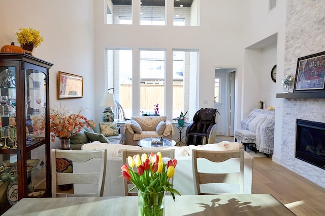 16098 Garganey Ct, Frisco, TX 75035 - living area featuring a towering ceiling, wood finished floors, a fireplace, and healthy amount of natural light