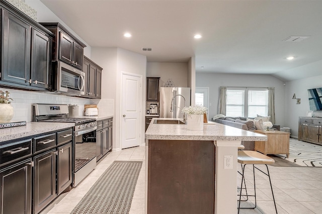 16556 White Fish Ln, Justin, TX 76247 - kitchen with appliances with stainless steel finishes, open floor plan, backsplash, a breakfast bar, and a sink