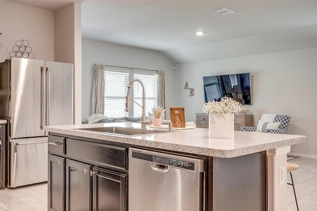 16556 White Fish Ln, Justin, TX 76247 - kitchen featuring stainless steel appliances, a sink, light tile patterned floors, open floor plan, and vaulted ceiling