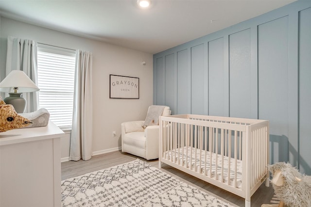 16556 White Fish Ln, Justin, TX 76247 - bedroom featuring light wood-type flooring, a nursery area, and baseboards