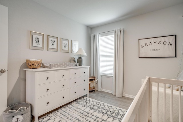 16556 White Fish Ln, Justin, TX 76247 - bedroom with light wood-style floors, a crib, and baseboards