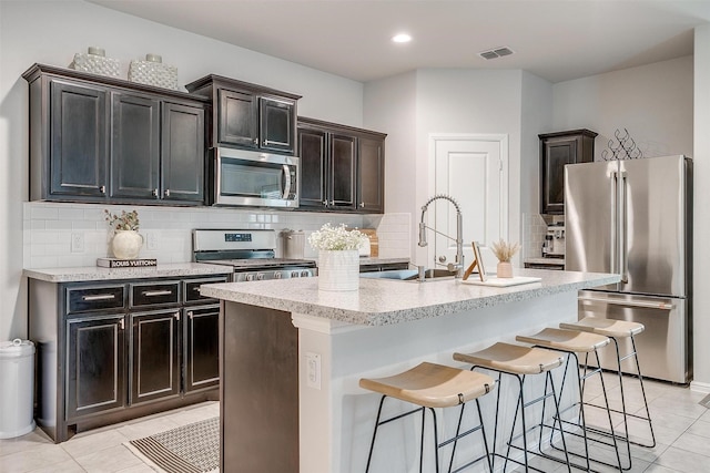 16556 White Fish Ln, Justin, TX 76247 - kitchen featuring stainless steel appliances, a sink, light tile patterned floors, tasteful backsplash, and recessed lighting
