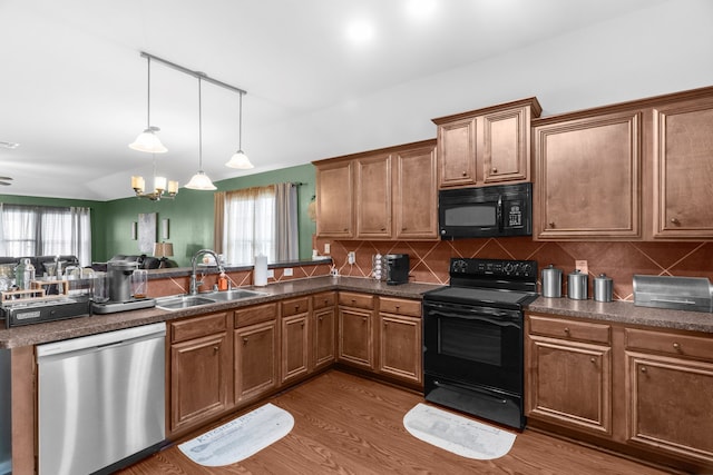 805 Canyon Pl, Desoto, TX 75115 - kitchen with black appliances, a sink, a peninsula, and dark countertops