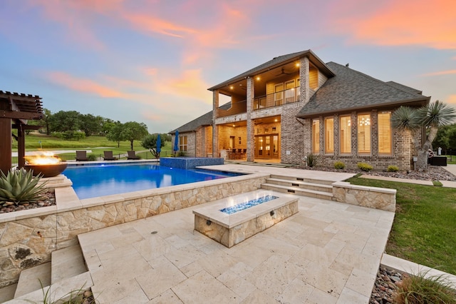 2100 Veranda Ave, Trophy Club, TX 76262 - pool at dusk with an outdoor fire pit, a patio, a ceiling fan, and an infinity pool