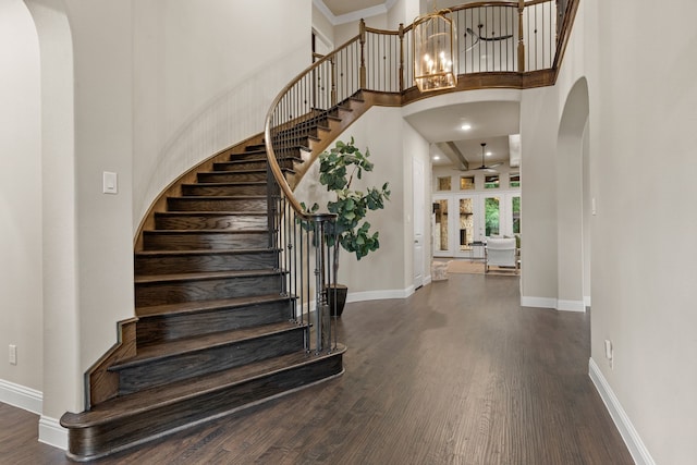 2100 Veranda Ave, Trophy Club, TX 76262 - stairway with wood finished floors, arched walkways, baseboards, a towering ceiling, and a chandelier