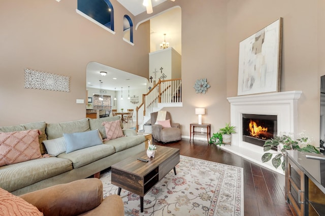 1090 Potter Ave, Rockwall, TX 75087 - living room with hardwood / wood-style floors, stairs, a lit fireplace, a high ceiling, and baseboards