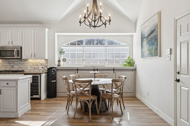 2628 Caddo Ct, Frisco, TX 75033 - dining space featuring lofted ceiling, light wood-type flooring, a chandelier, and beverage cooler