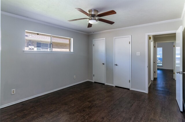 8351-8353 Lullwater Dr, Dallas, TX 75218 - unfurnished bedroom featuring dark wood finished floors, crown molding, baseboards, and a ceiling fan
