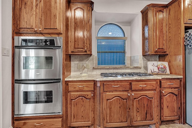 1217 Kent Brown Rd, Garland, TX 75044 - kitchen featuring stainless steel appliances, decorative backsplash, and brown cabinets