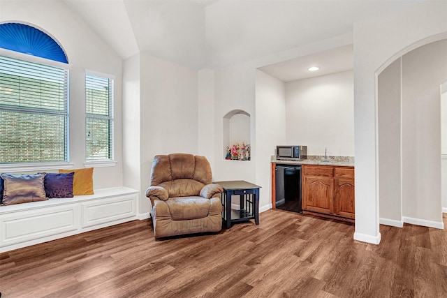 1217 Kent Brown Rd, Garland, TX 75044 - living area featuring wood finished floors, baseboards, arched walkways, lofted ceiling, and recessed lighting