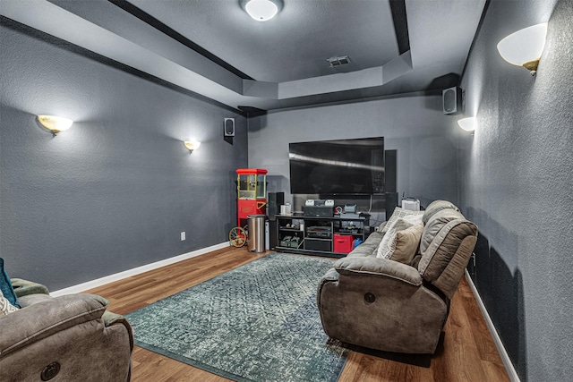 1217 Kent Brown Rd, Garland, TX 75044 - living area featuring wood finished floors, a textured wall, baseboards, and a raised ceiling