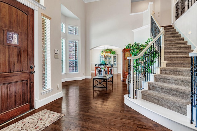 1217 Kent Brown Rd, Garland, TX 75044 - entryway with arched walkways, wood finished floors, a high ceiling, stairway, and baseboards