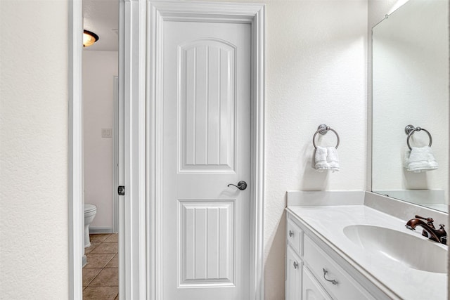 1217 Kent Brown Rd, Garland, TX 75044 - bathroom featuring tile patterned flooring, vanity, toilet, and a textured wall