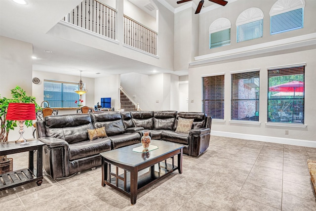 1217 Kent Brown Rd, Garland, TX 75044 - living area with a ceiling fan, stairway, a towering ceiling, light tile patterned floors, and baseboards
