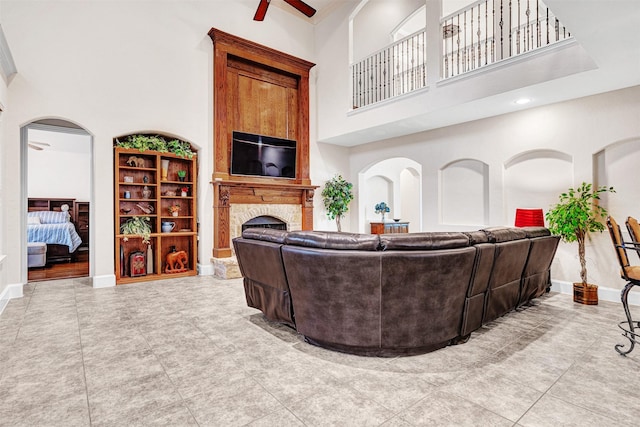 1217 Kent Brown Rd, Garland, TX 75044 - living room featuring a towering ceiling, a fireplace, ceiling fan, and baseboards