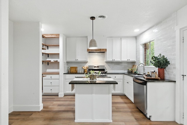 1423 W Ball St, Weatherford, TX 76086 - kitchen featuring appliances with stainless steel finishes, backsplash, a center island, white cabinets, and recessed lighting