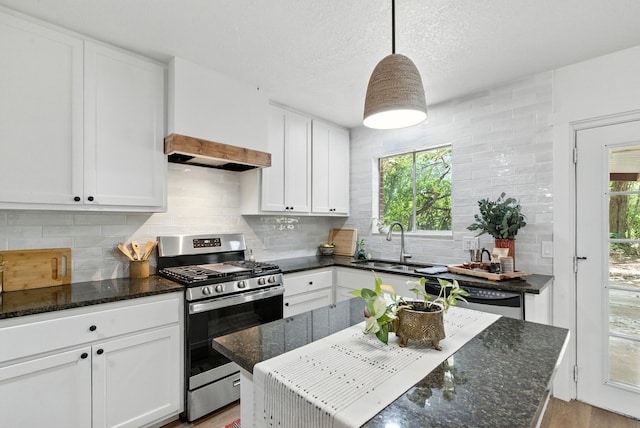 1423 W Ball St, Weatherford, TX 76086 - kitchen featuring appliances with stainless steel finishes, white cabinetry, light wood-type flooring, and dark stone counters