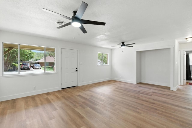 1423 W Ball St, Weatherford, TX 76086 - unfurnished living room with a ceiling fan, light wood-style floors, and a textured ceiling