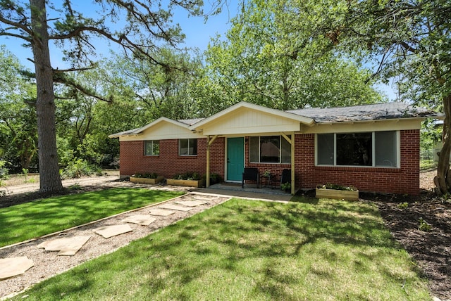 1423 W Ball St, Weatherford, TX 76086 - view of front of house featuring brick siding, a front lawn, and a shingled roof