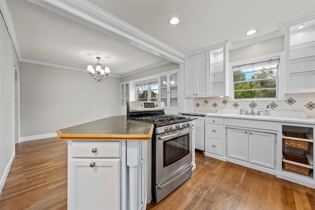 2530 Colcord, Waco, TX 76707 - kitchen featuring stainless steel range with gas cooktop, hardwood / wood-style flooring, tasteful backsplash, ornamental molding, and white cabinets