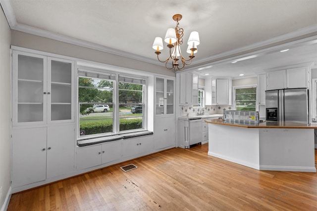2530 Colcord, Waco, TX 76707 - kitchen featuring dishwashing machine, stainless steel refrigerator with ice dispenser, light wood-style flooring, a chandelier, and crown molding