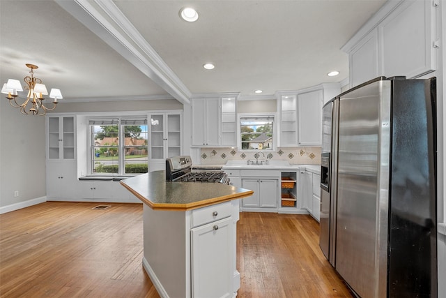 2530 Colcord, Waco, TX 76707 - kitchen with appliances with stainless steel finishes, ornamental molding, light wood-style flooring, white cabinetry, and a chandelier