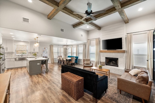 1321 Thistle Hill Trl, Weatherford, TX 76087 - living area featuring coffered ceiling, a ceiling fan, plenty of natural light, beamed ceiling, and light wood-style floors