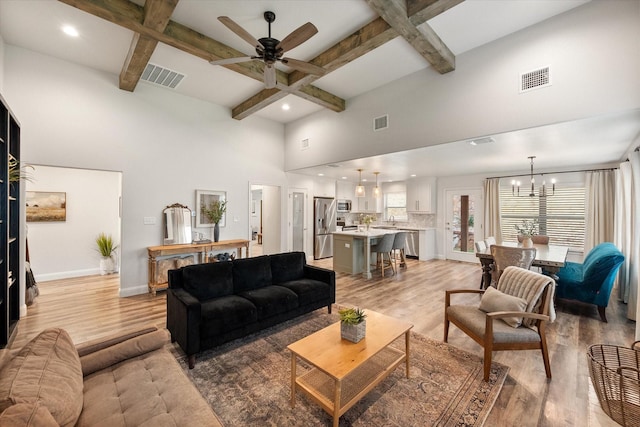 1321 Thistle Hill Trl, Weatherford, TX 76087 - living room with light wood-type flooring, a chandelier, a ceiling fan, beamed ceiling, and baseboards