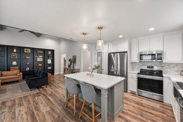 1321 Thistle Hill Trl, Weatherford, TX 76087 - kitchen featuring stainless steel appliances, white cabinetry, decorative backsplash, dark wood-type flooring, and a kitchen island