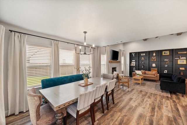 1321 Thistle Hill Trl, Weatherford, TX 76087 - dining space with a chandelier, wood finished floors, and a fireplace