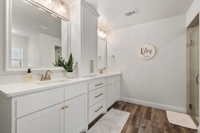 1321 Thistle Hill Trl, Weatherford, TX 76087 - bathroom with wood finished floors, a shower stall, baseboards, and double vanity