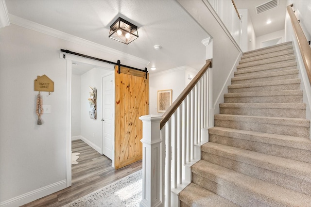 1321 Thistle Hill Trl, Weatherford, TX 76087 - stairway featuring a barn door, wood finished floors, baseboards, crown molding, and recessed lighting