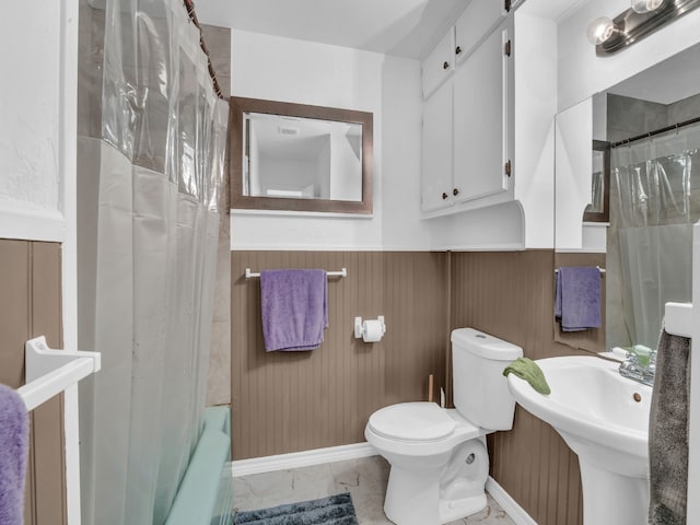 323 W Rentz St, Weatherford, TX 76086 - full bathroom with a wainscoted wall, toilet, curtained shower, marble finish flooring, and a bath